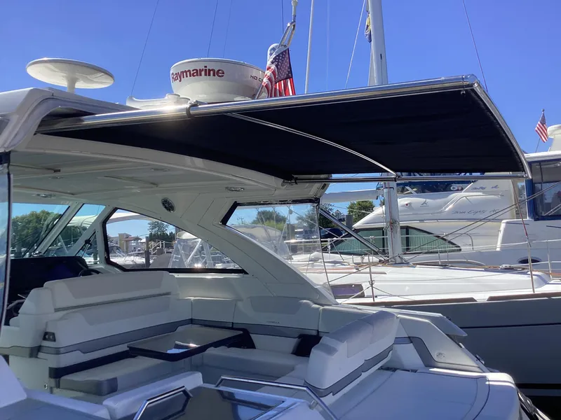 Slide: The Image of 2020 Formula 380 Super Sport Crossover yacht with shaded seating area at marina. - 28