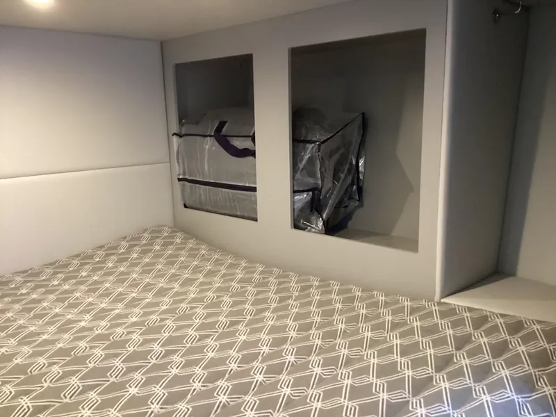 Slide: The Image of 2020 Formula 380 Super Sport Crossover cabin with patterned bedding and storage compartments. - 49
