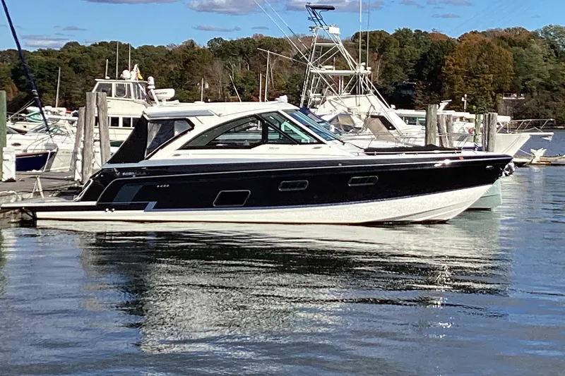 Slide: The Image of 2020 Formula 380 Super Sport Crossover I/O docked in a marina, surrounded by other boats. - 80