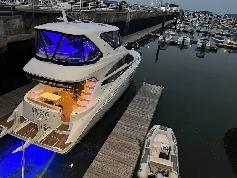 Slide: The Image of 2012 Meridian 441 Sedan yacht docked at marina with blue and white lighting. - 14