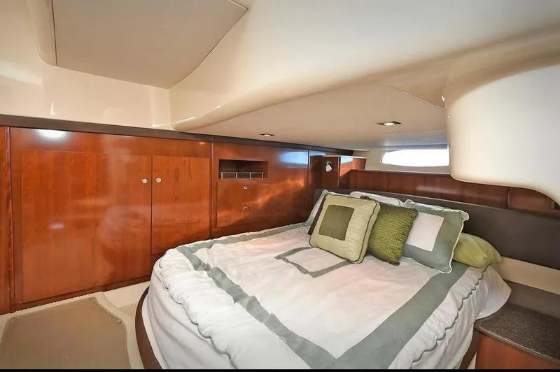 Slide: The Image of Luxurious bedroom interior of 2012 Meridian 441 Sedan yacht with wood cabinetry and cozy bedding. - 23