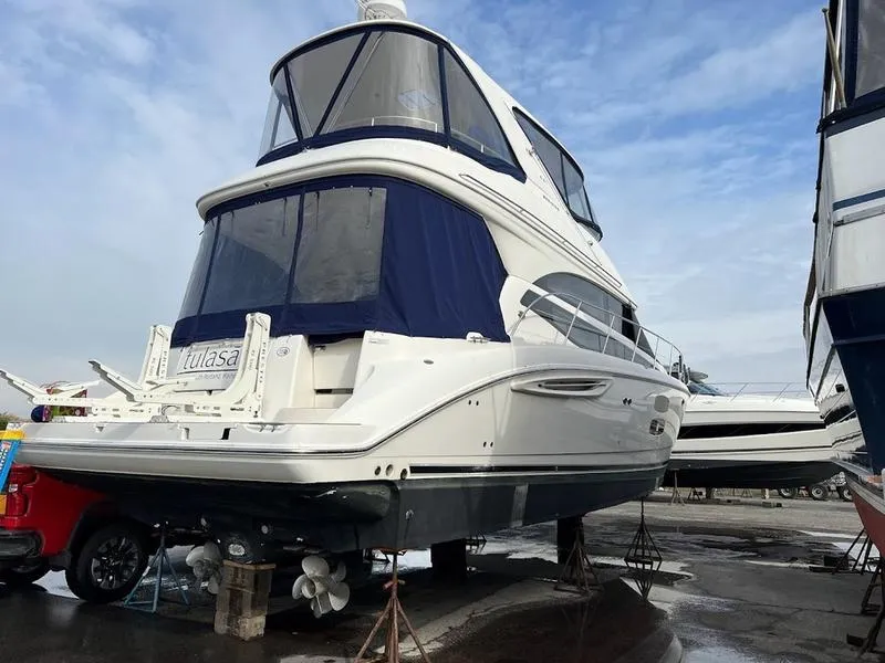 Slide: The Image of 2012 Meridian 441 Sedan yacht on dry dock, featuring sleek design and spacious upper deck. - 4