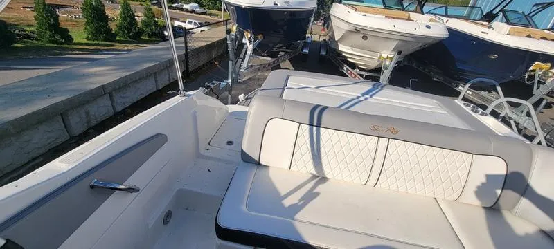 Slide: The Image of 2017 Sea Ray 220 SD boat interior with cushioned seating and docked boats in background. - 14