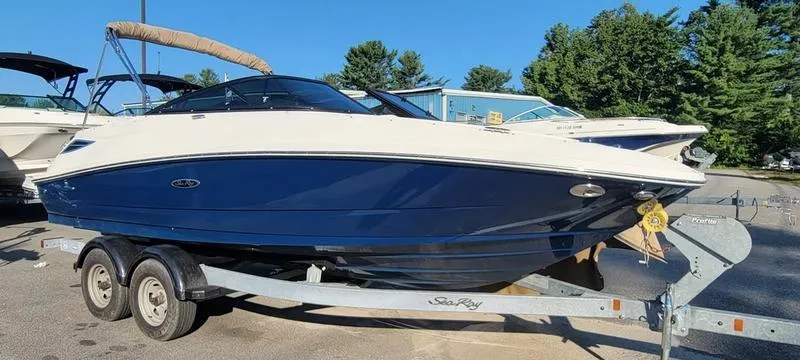 Slide: The Image of 2017 Sea Ray 220 SD boat on trailer, blue and white design, parked outdoors. - 24