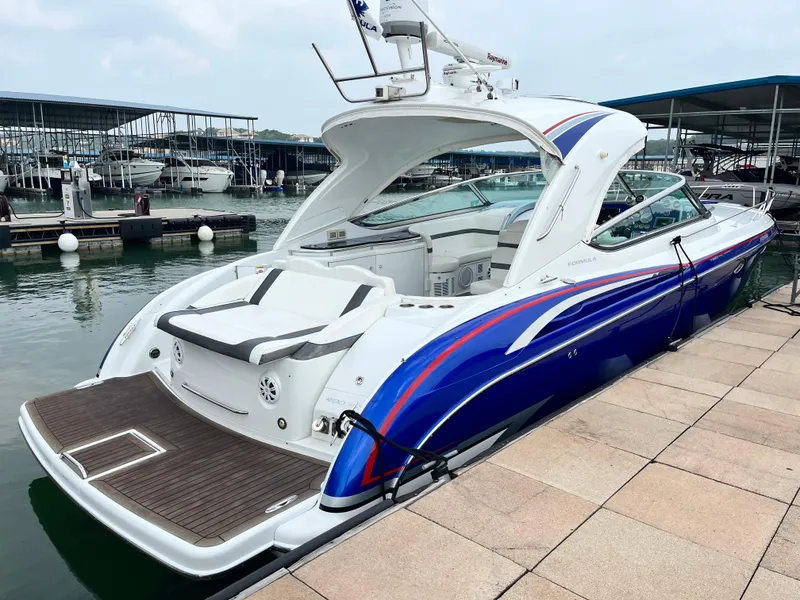 Slide: The Image of 2013 Formula 400 SS FX8 boat docked at marina, sleek design, blue and white exterior. - 10