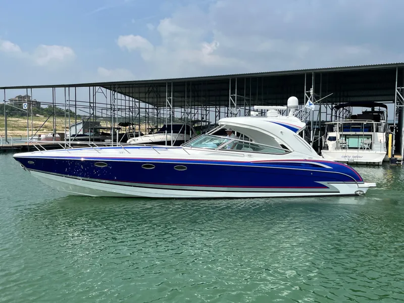 Slide: The Image of 2013 Formula 400 SS FX8 boat docked on calm water, featuring sleek blue and white design. - 2