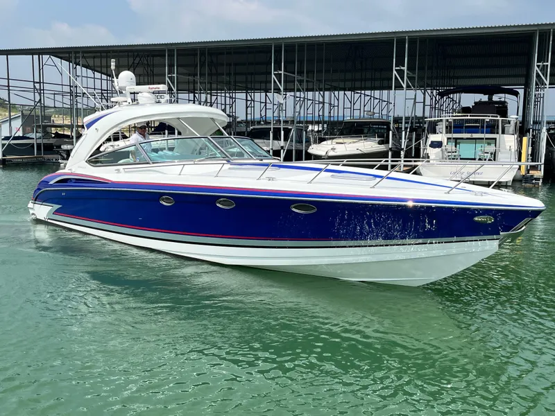 Slide: The Image of 2013 Formula 400 SS FX8 boat docked in marina, blue and white exterior. - 9