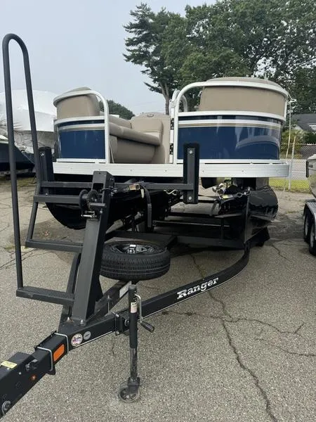 Slide: The Image of 2023 Ranger R 200C pontoon boat on trailer, parked outdoors. - 2