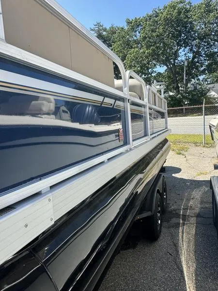 Slide: The Image of 2023 Ranger R 200C pontoon boat, blue and white exterior, parked outdoors. - 3
