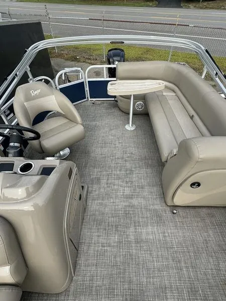 Slide: The Image of 2023 Ranger R 200C boat interior with beige seating and steering console. - 7