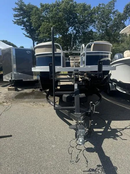 Slide: The Image of 2023 Ranger R 200C boat on trailer, parked outdoors, with trees in the background. - 9