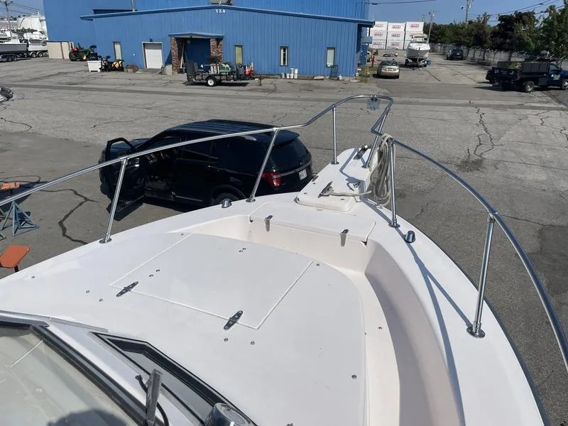 Slide: The Image of 1997 Grady-White 268 Islander boat docked near a blue warehouse. - 10