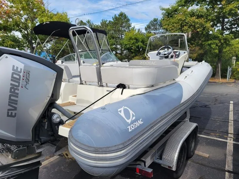 Slide: The Image of 2018 Zodiac NZO 22 boat on trailer with Evinrude engine, parked outdoors. - 3