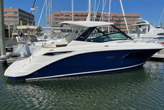 The Image of 2020 Sea Ray Sundancer 320 yacht docked in marina, blue and white exterior. - 0