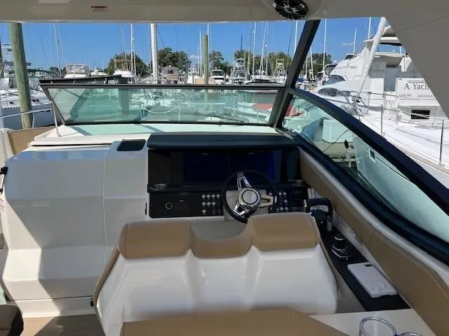 Slide: The Image of 2020 Sea Ray Sundancer 320 helm with modern controls and spacious seating at marina. - 6