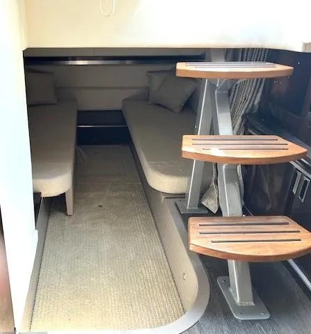 Slide: The Image of 2020 Sea Ray Sundancer 320 cabin interior with twin beds and wooden steps. - 7