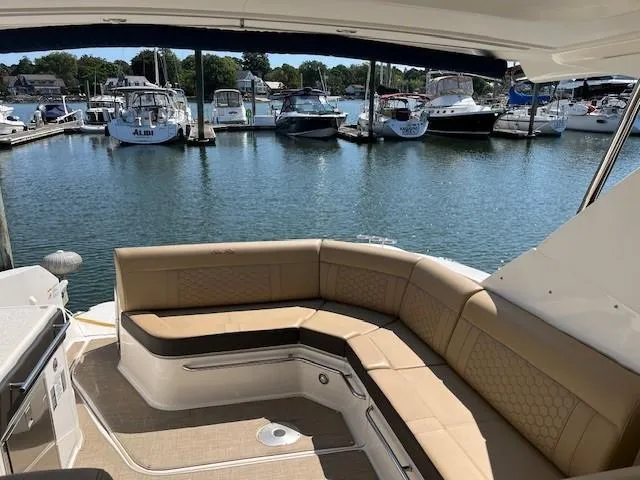 Slide: The Image of Sea Ray Sundancer 320, 2020 model, with spacious seating in a marina setting. - 8