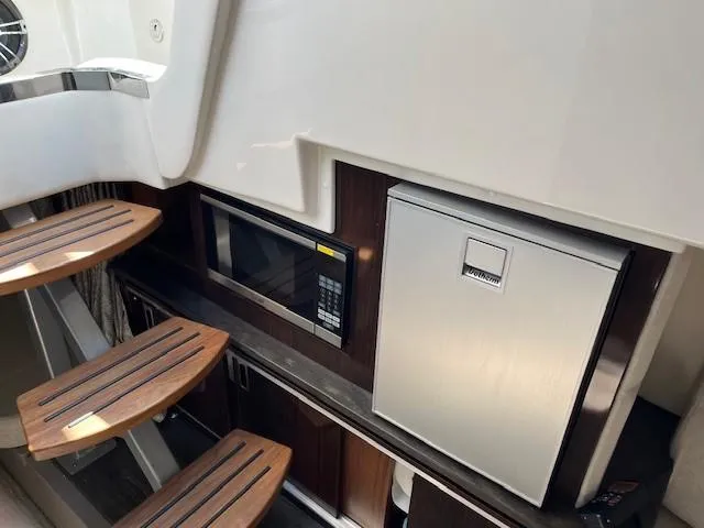 Slide: The Image of 2020 Sea Ray Sundancer 320 interior with microwave and compact fridge. - 9