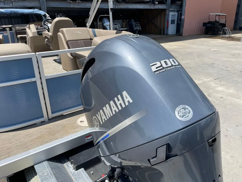 Slide: The Image of 2020 Bennington SX 23 SXSR with Yamaha 200 outboard motor in a marina setting. - 16