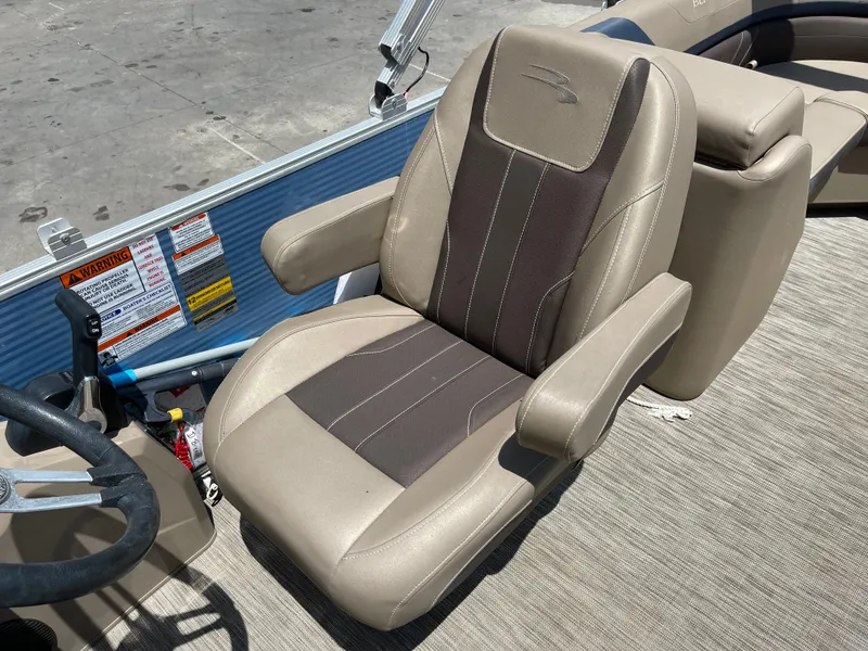 Slide: The Image of 2020 Bennington SX 23 SXSR boat seat, beige and brown upholstery, armrests, and steering wheel visible. - 28