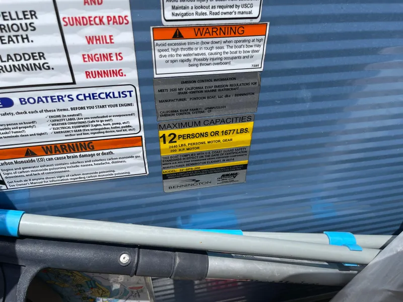 Slide: The Image of Warning labels and capacity limits on a 2020 Bennington SX 23 SXSR boat. - 29
