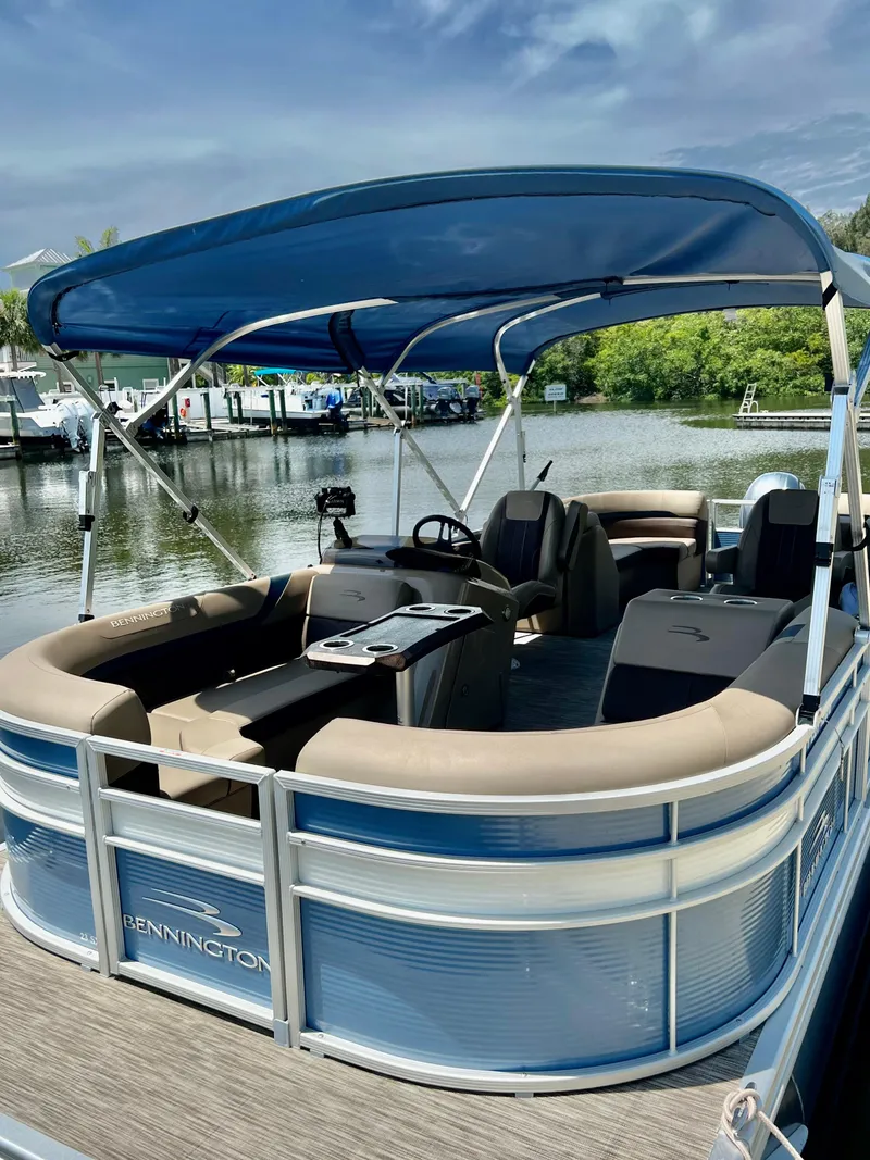 Slide: The Image of 2020 Bennington SX 23 SXSR pontoon boat with blue canopy on a serene lake. - 3