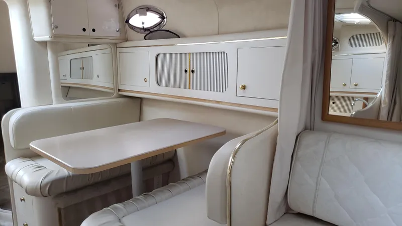 Slide: The Image of Interior of 2000 Sea Ray 290 Sundancer, featuring elegant seating and cabinetry. - 10