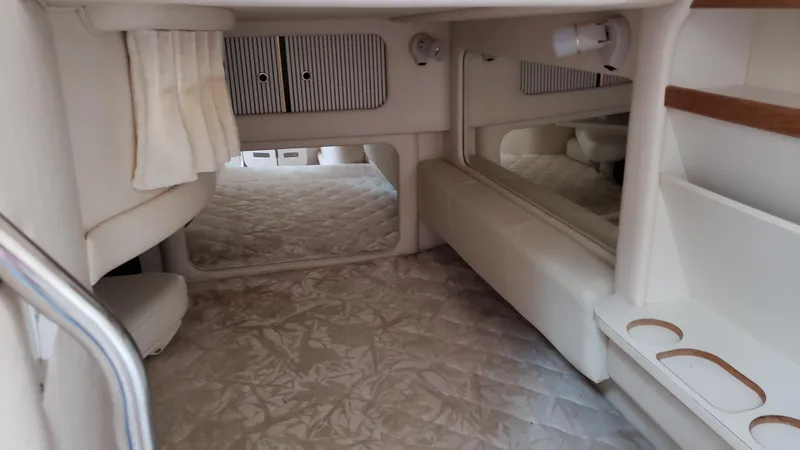 Slide: The Image of Interior cabin of 2000 Sea Ray 290 Sundancer, featuring cozy sleeping area and storage. - 11