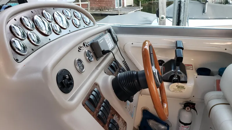 Slide: The Image of Cockpit of 2000 Sea Ray 290 Sundancer with wooden steering wheel and control panel. - 19