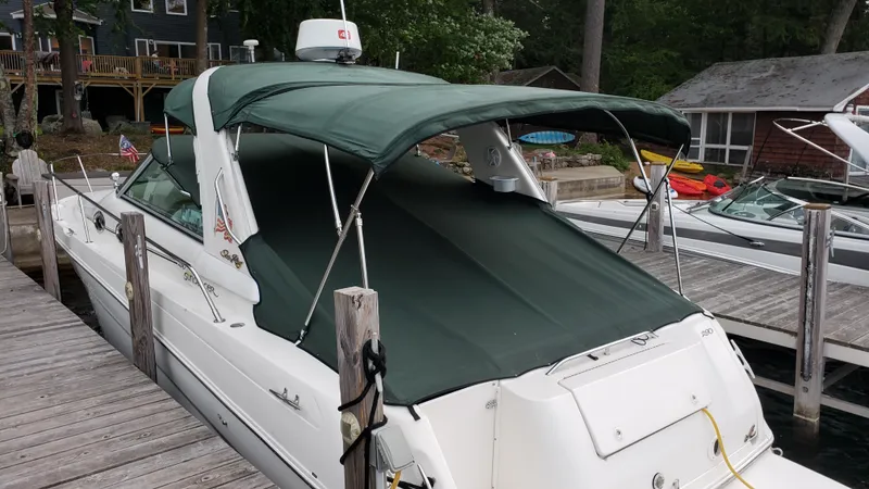 Slide: The Image of 2000 Sea Ray 290 Sundancer docked, featuring green canopy and white hull. - 3