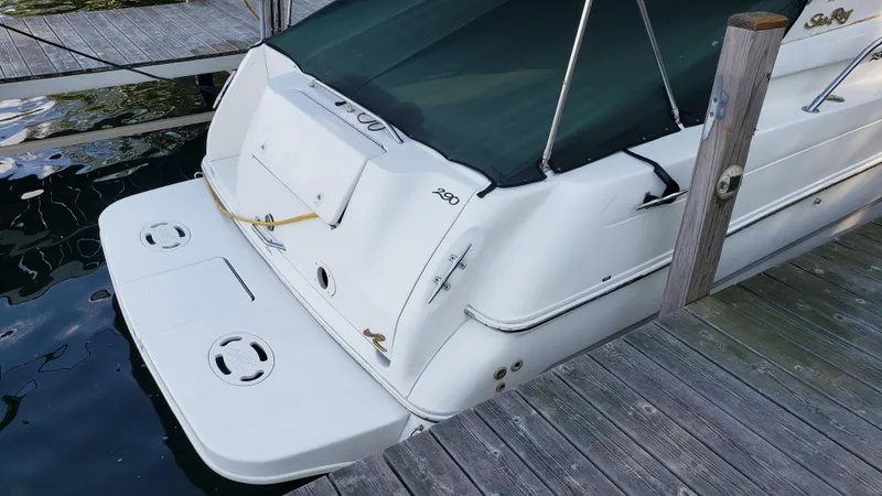 Slide: The Image of 2000 Sea Ray 290 Sundancer docked, rear view with swim platform and cover. - 4