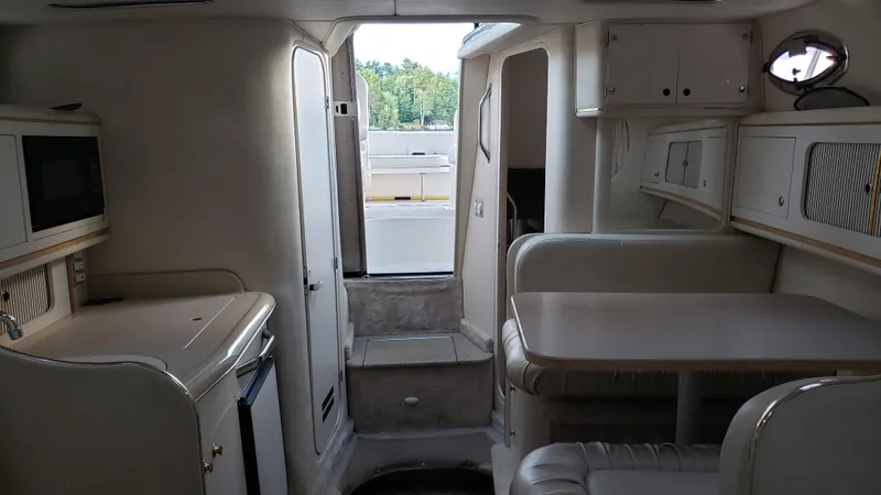 Slide: The Image of Interior of 2000 Sea Ray 290 Sundancer boat, featuring kitchenette and seating area. - 9