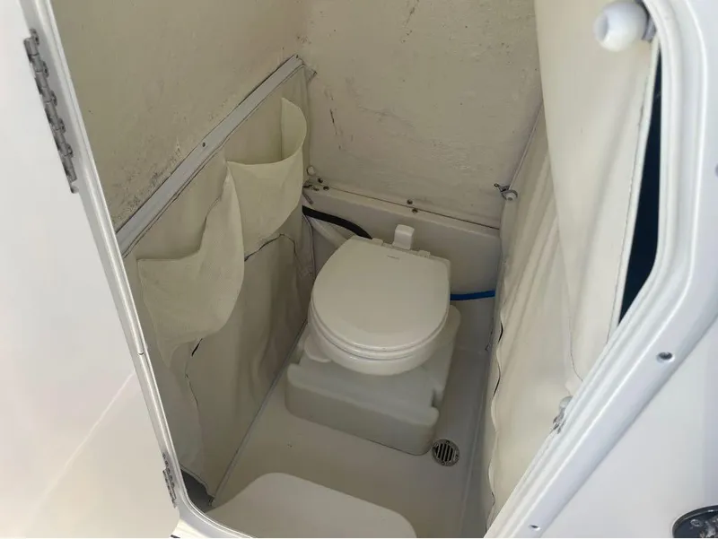 Slide: The Image of 2021 Key West 263FS boat interior with compact marine toilet. - 16