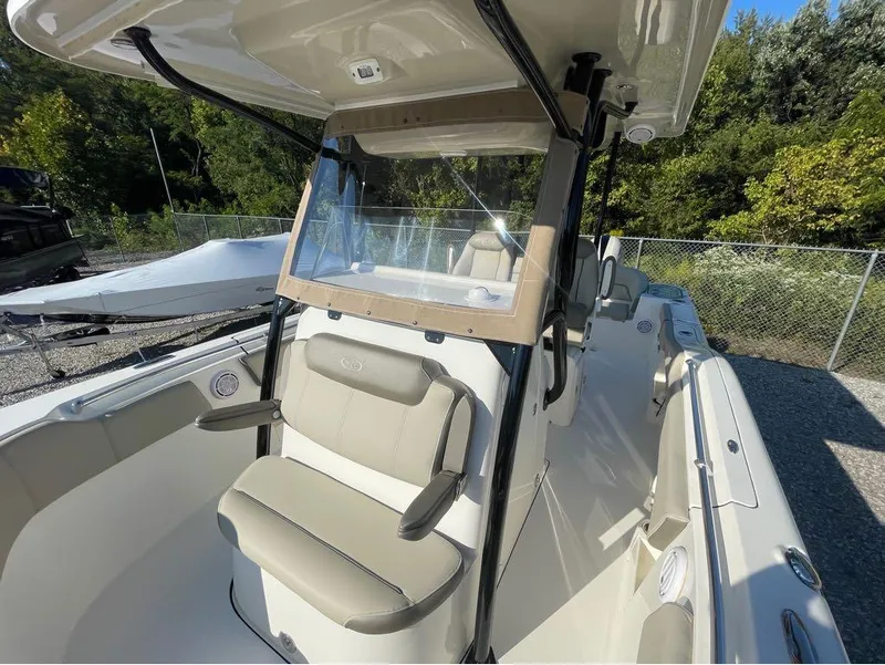 Slide: The Image of 2021 Key West 263FS boat interior with seating and console, parked outdoors. - 17