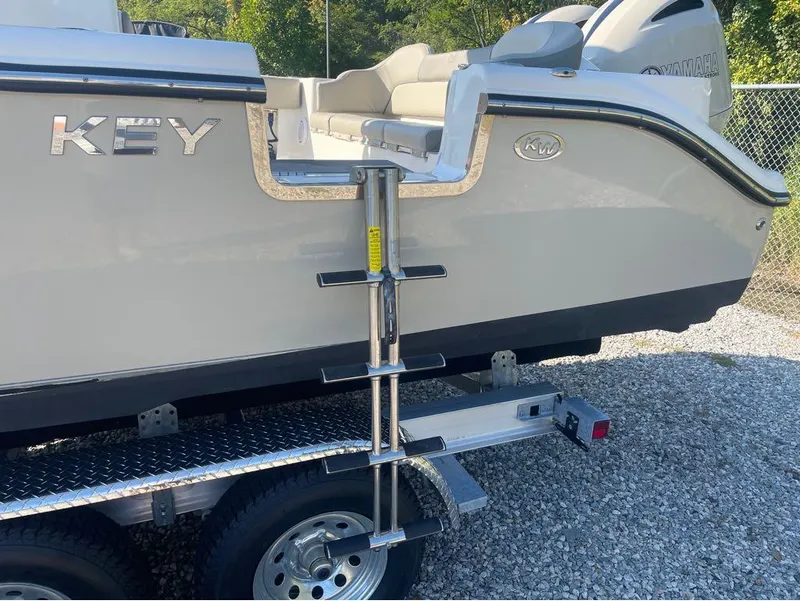 Slide: The Image of 2021 Key West 263FS boat on trailer with ladder, parked on gravel. - 20
