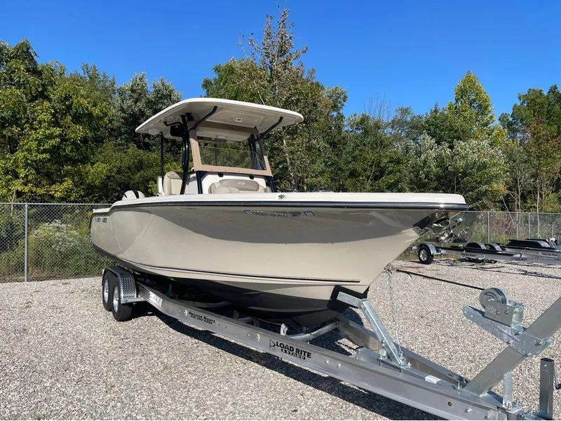 Slide: The Image of 2021 Key West 263FS boat on trailer, parked outdoors with trees in background. - 25