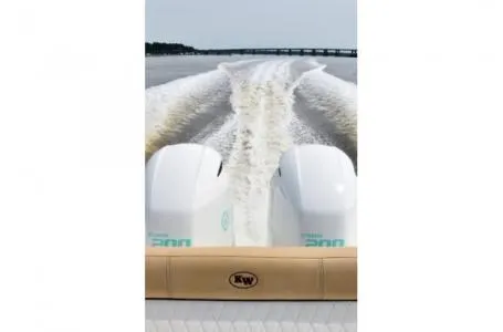 Slide: The Image of 2021 Key West 263FS boat with twin engines creating a wake on open water. - 33