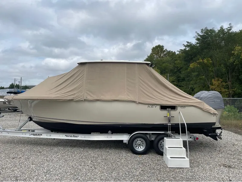 Slide: The Image of 2021 Key West 263FS boat covered on trailer, parked outdoors. - 36