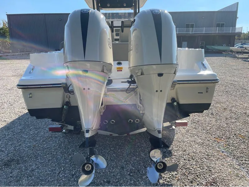 Slide: The Image of 2021 Key West 263FS boat with dual outboard engines in a gravel lot. - 38