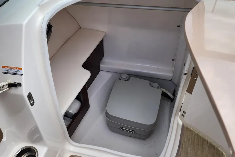 Slide: The Image of 2015 Chaparral 224 Sunesta boat interior with compact portable toilet. - 10