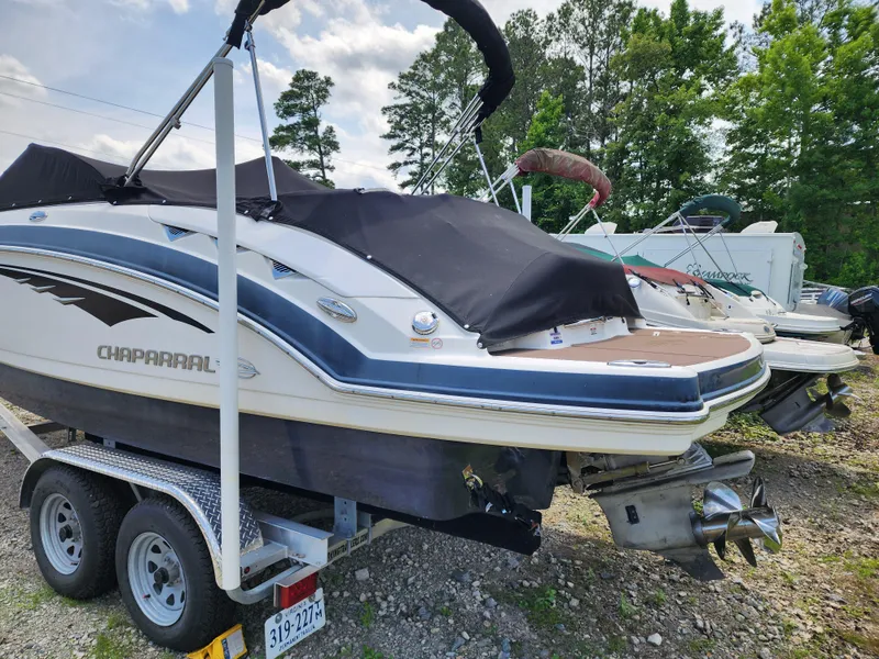 Slide: The Image of 2015 Chaparral 224 Sunesta boat on trailer, covered, parked outdoors. - 2