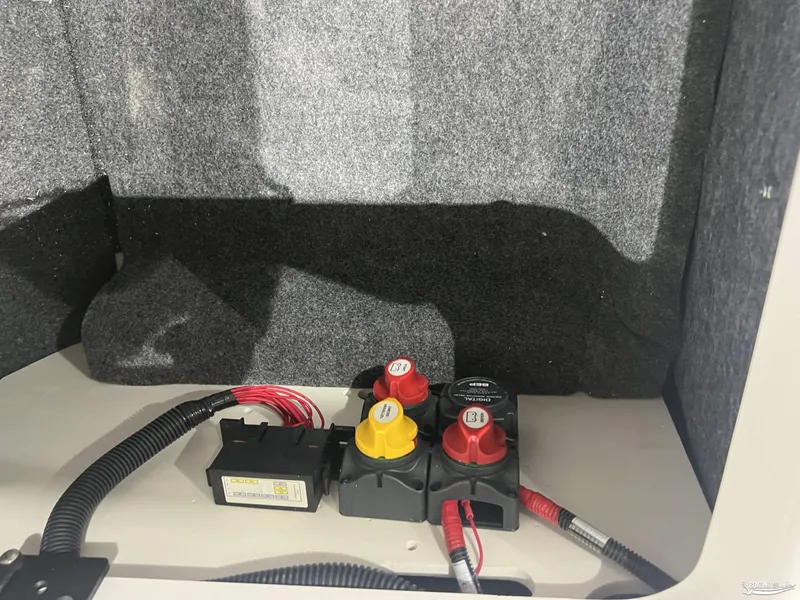 Slide: The Image of 2025 Yamaha AR220 boat battery compartment with wiring and switches. - 8