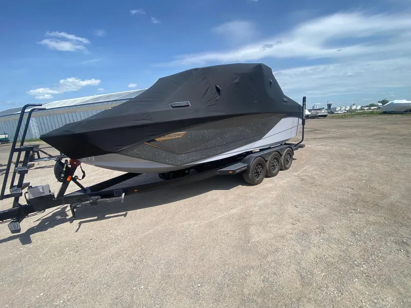 Slide: The Image of 2022 Nautique Super Air Nautique G23 Paragon boat covered on a trailer under a blue sky. - 30