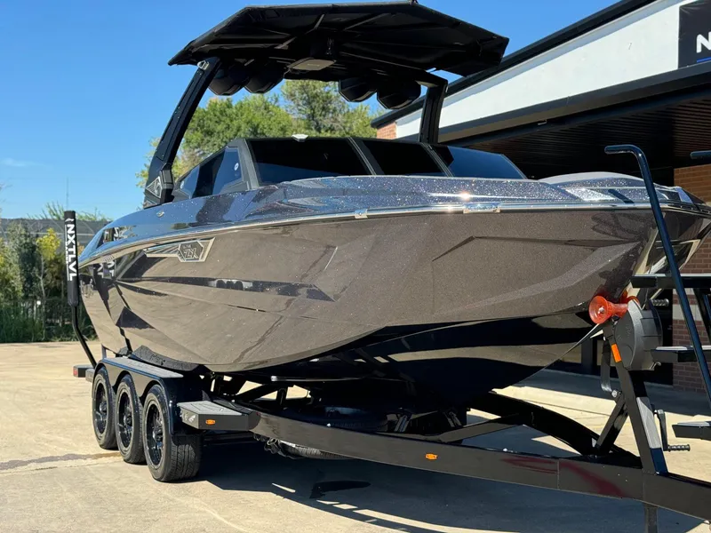 Slide: The Image of 2024 Tigé 23ZX Ultre' boat on trailer, sleek design, parked outdoors. - 5