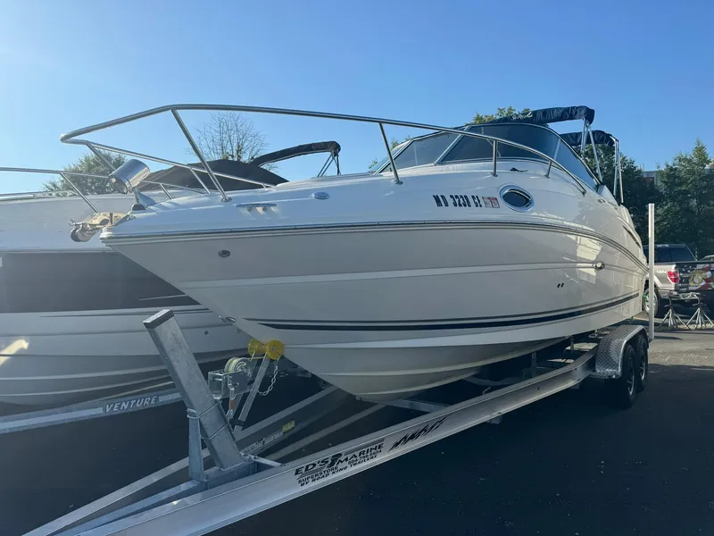 Slide: The Image of 2009 Sea Ray 240 Sundancer boat on trailer in sunny outdoor setting. - 0