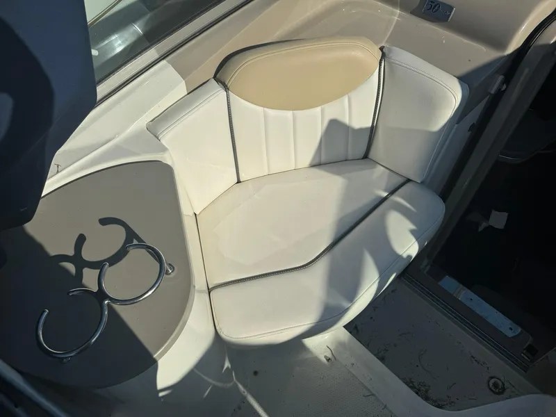 Slide: The Image of 2009 Sea Ray 240 Sundancer interior with beige seating and cup holders. - 12