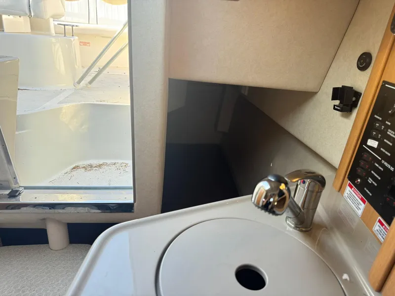Slide: The Image of Interior view of 2009 Sea Ray 240 Sundancer boat, featuring a compact sink and cabin area. - 15