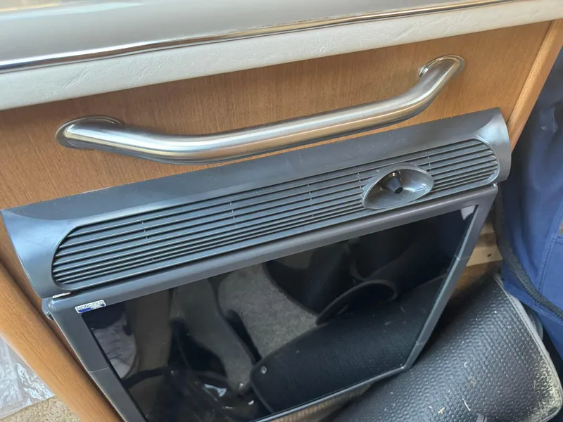 Slide: The Image of 2009 Sea Ray 240 Sundancer interior with a compact black refrigerator. - 18