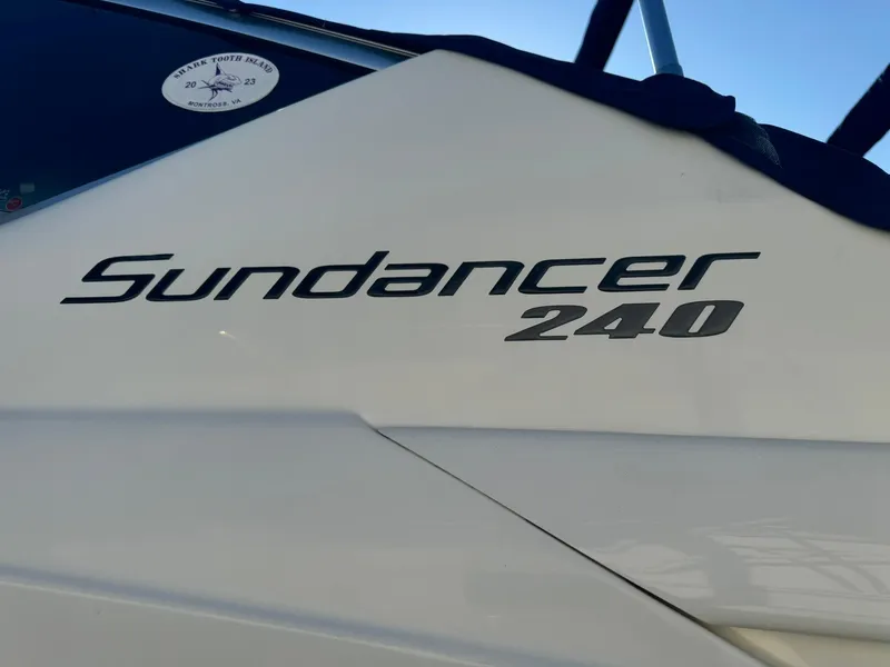 Slide: The Image of 2009 Sea Ray 240 Sundancer boat logo on white hull. - 3