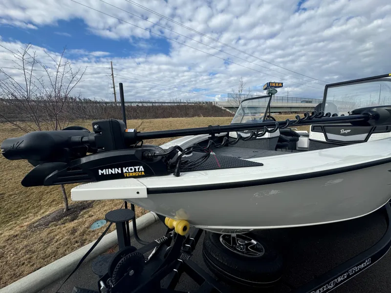 Slide: The Image of 2024 Ranger VX1988 WT boat with Minn Kota Terrova motor, parked outdoors under cloudy sky. - 2
